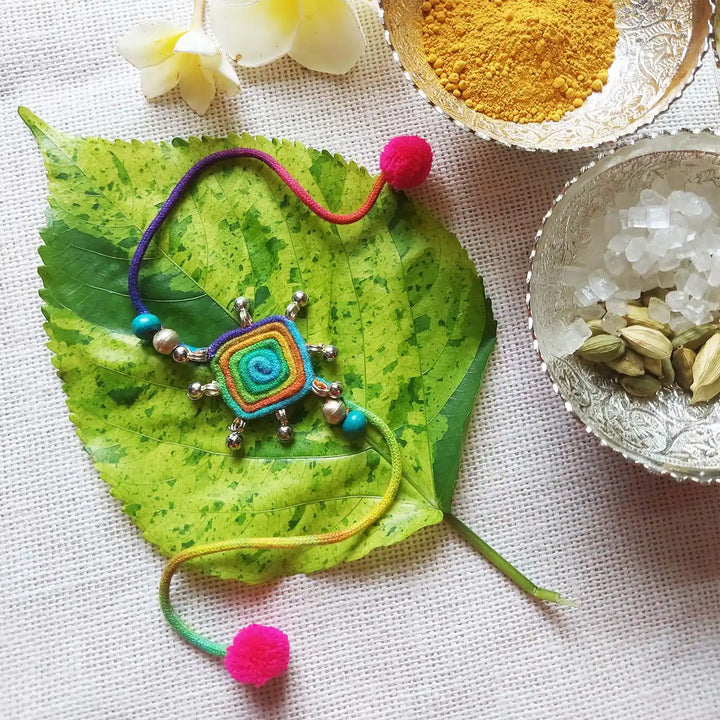 Handmade Dori Work Beaded Multicolor Rakhi With Roli Chawal - Lying on Leaf with Ingredients