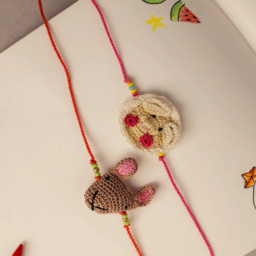 Handmade Crochet Sheep And Mice Theme Kids Rakhi With Roli Chawal Set Of 2 - Flat Lay Angled View