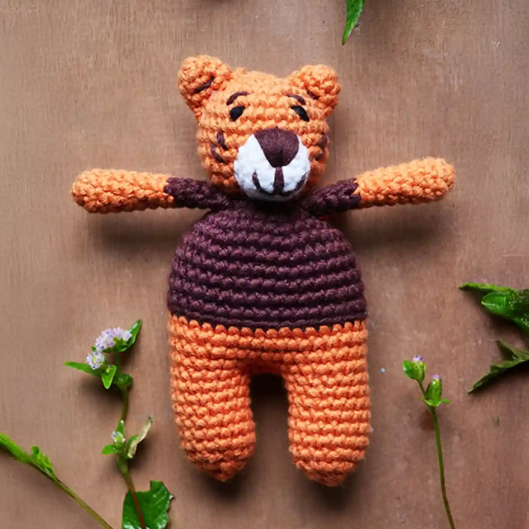 Handmade Crochet Tiger Theme Kids Rakhi And Toy Combo With Roli Chawal Set Of 2 - Front View on Wood Background