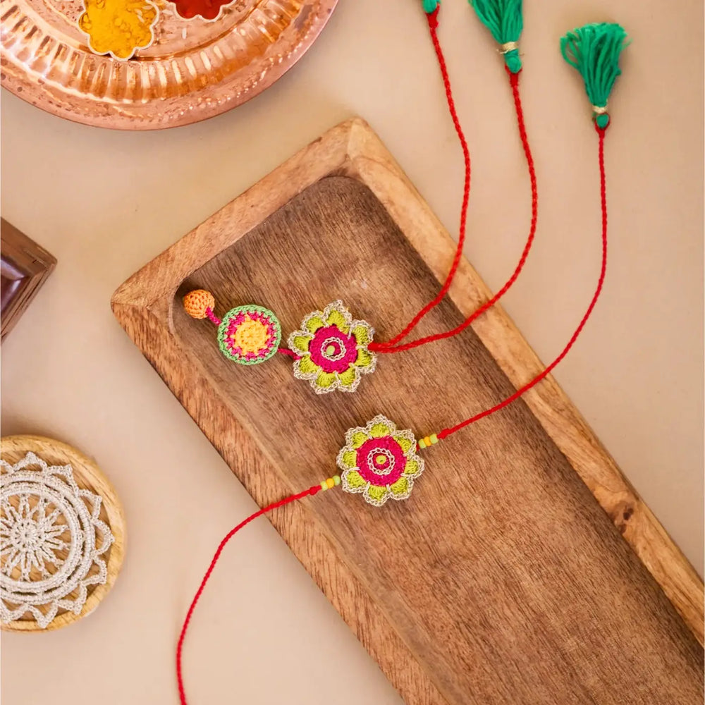 Handmade Crochet Green And Pink Bhaiya Bhabhi Rakhi With Roli Chawal Set Of 2 - Top View with Background Items