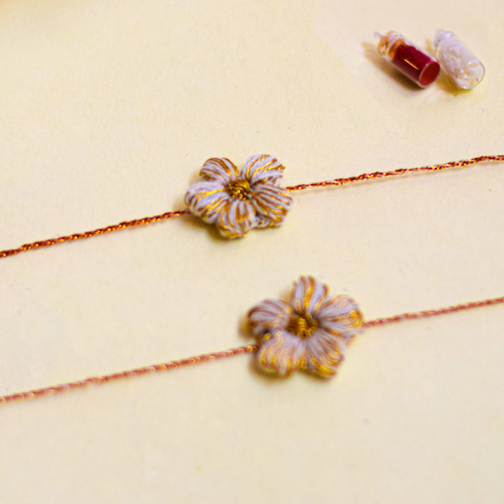 Handmade Crochet Flower And Ghungroo Design Bhaiya Bhabhi Rakhi With Roli Chawal - Close-up of two floral bracelets