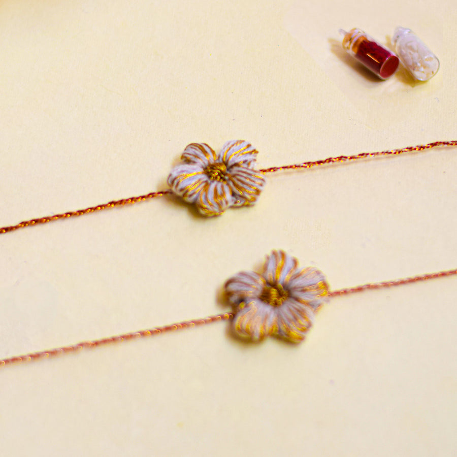 Handmade Crochet Flower And Ghungroo Design Bhaiya Bhabhi Rakhi With Roli Chawal - Close-up of two floral bracelets