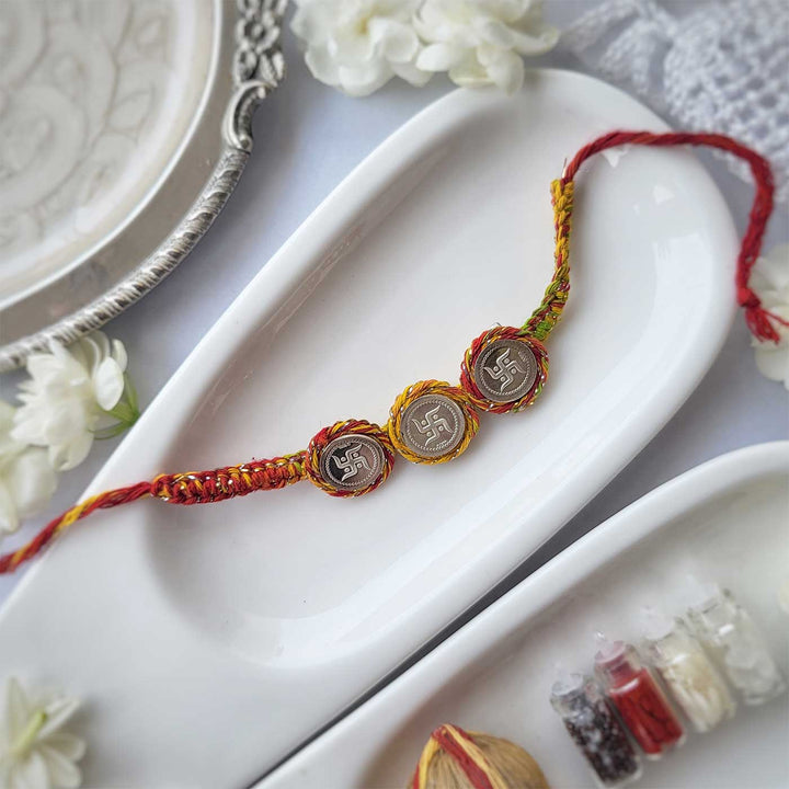 Handmade Three Swatik Coin Design Silver Rakhi Hamper With Roli Chawal For Brother - Full product layout on white tray