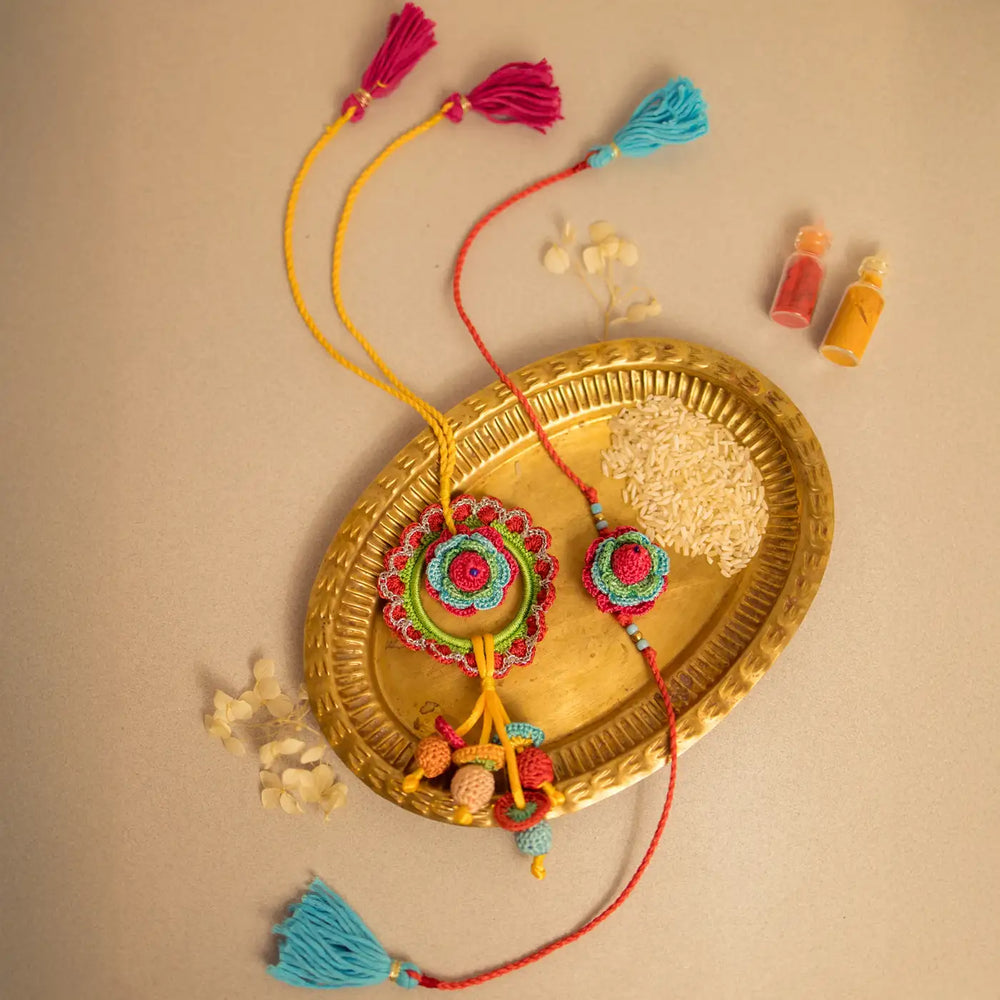 Handmade Crochet Rose Bhaiya Bhabhi Rakhi With Roli Chawal Set Of 2 - Styled on decorative brass plate