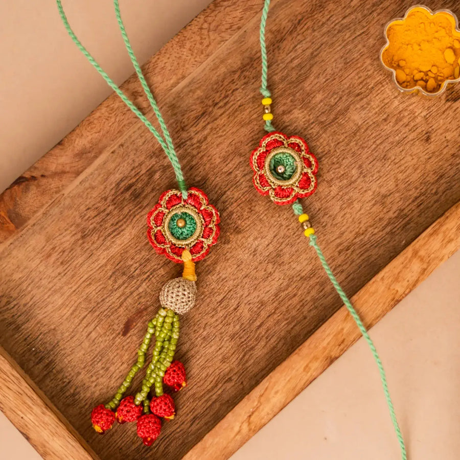 Handmade Crochet Green And Red Flower Bhaiya Bhabhi Rakhi With Roli Chawal Set Of 2 - Close-up of decorative details