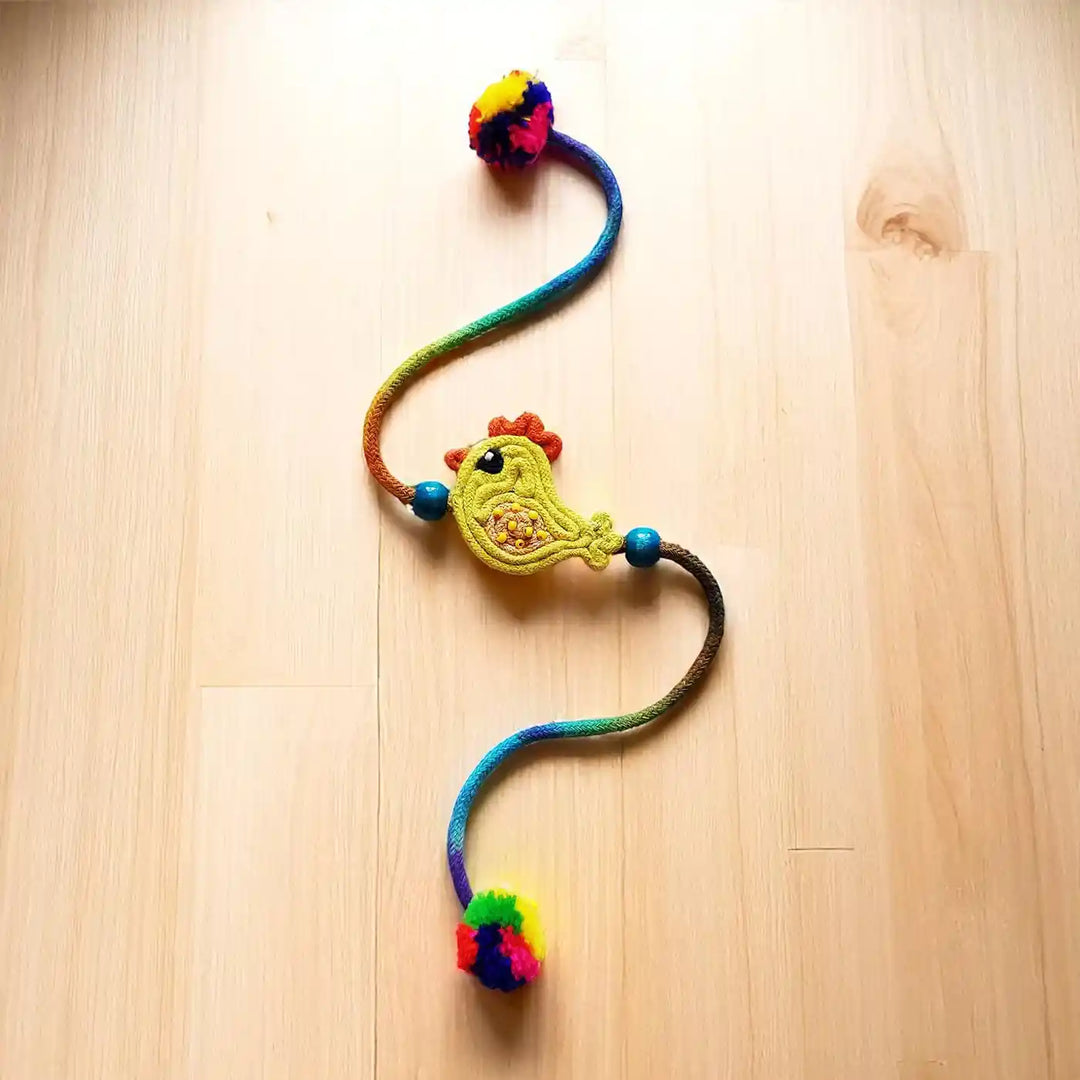 Handmade Dori Work Cute Chick Kids Rakhi With Roli Chawal - Full View on Wooden Surface