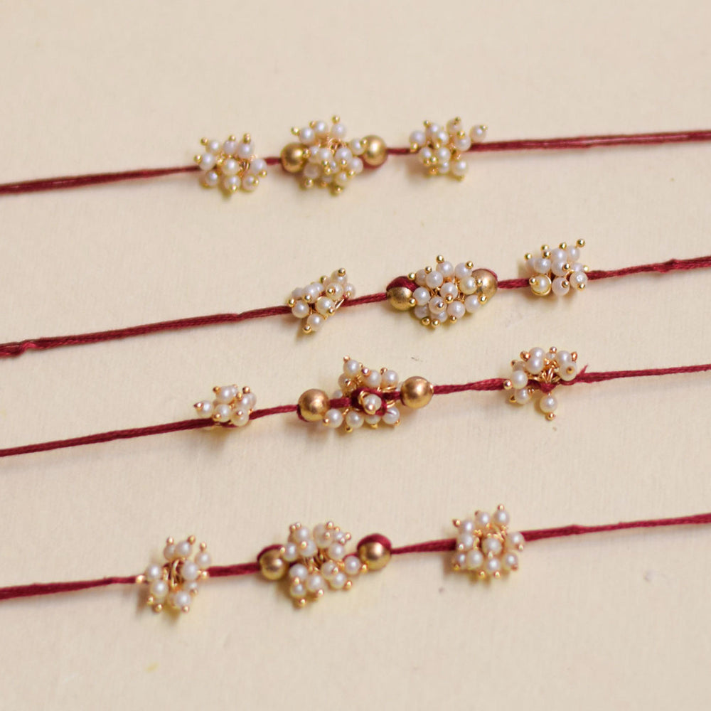 Handmade Triple Bajra Ghungroo And Pearl Rakhi With Roli Chawal - Four Bracelets Close-up View