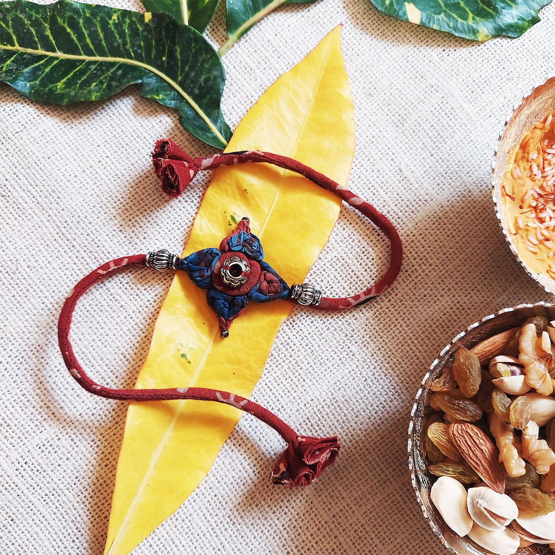 Handmade Dori Work Flower Ajrakh Rakhi With Roli Chawal - Styled with Natural Elements