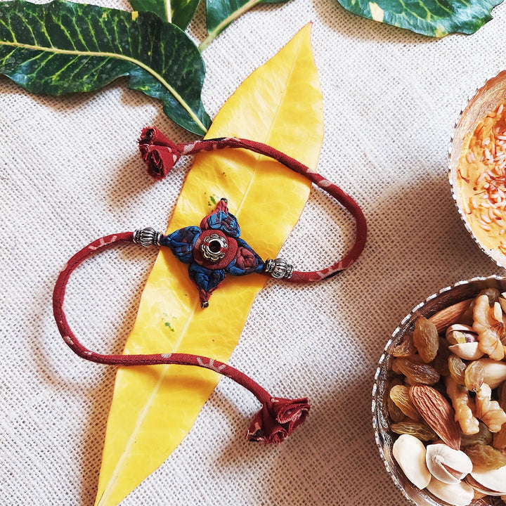 Handmade Dori Work Flower Ajrakh Rakhi With Roli Chawal - Styled with Natural Elements