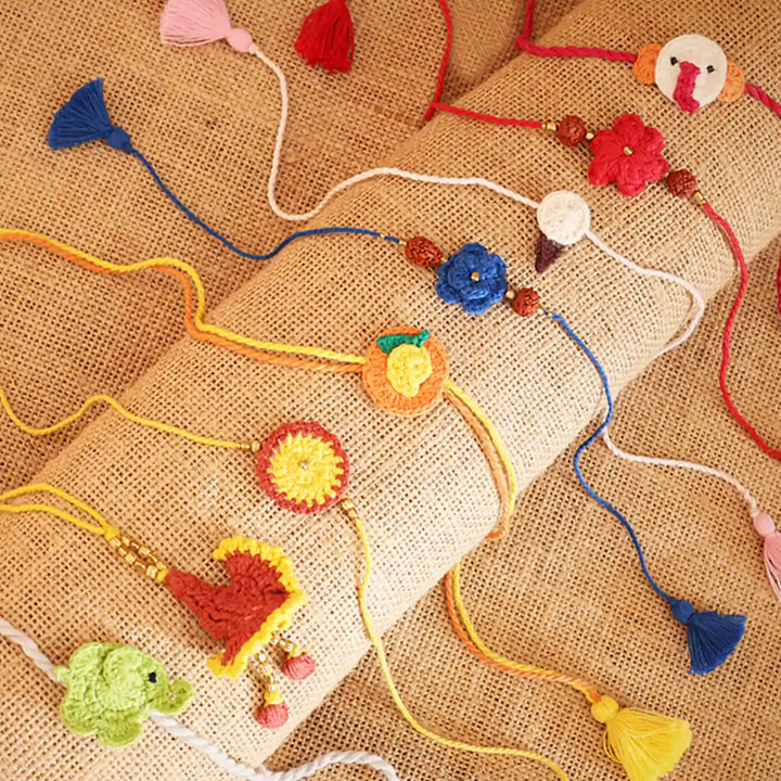 Handmade Crochet Multicolor Family Rakhi With Roli Chawal Set Of 8 - Close-up of Rakhi designs