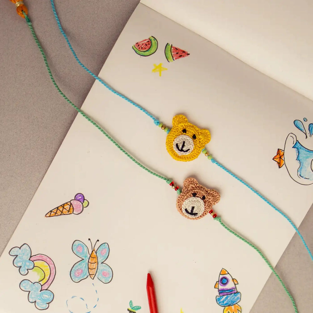 Handmade Crochet Bear Theme Kids Rakhi With Roli Chawal Set Of 2 - Laid on Illustrated Surface