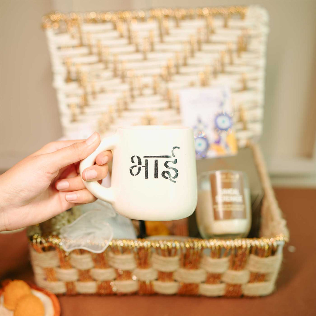 Personalized Handmade Crochet Evil Eye Theme Rakhi Hamper Includes 1 Basket 1 Mug 1 Candle 1 Crochet Flower 2 Rakhis 1 Roli Chawal And 1 Message Card - Mug Held in Hand Close-up