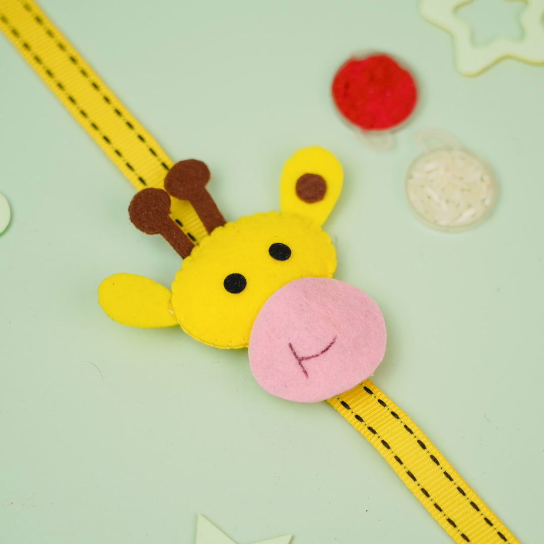 Handmade Giraffe Theme Felt Kids Rakhi With Roli Chawal - Flat Lay with Toys Nearby
