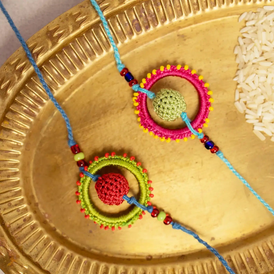 Handmade Crochet Fanaa Rakhi With Roli Chawal Set Of 2 - Close-up of woven thread rings