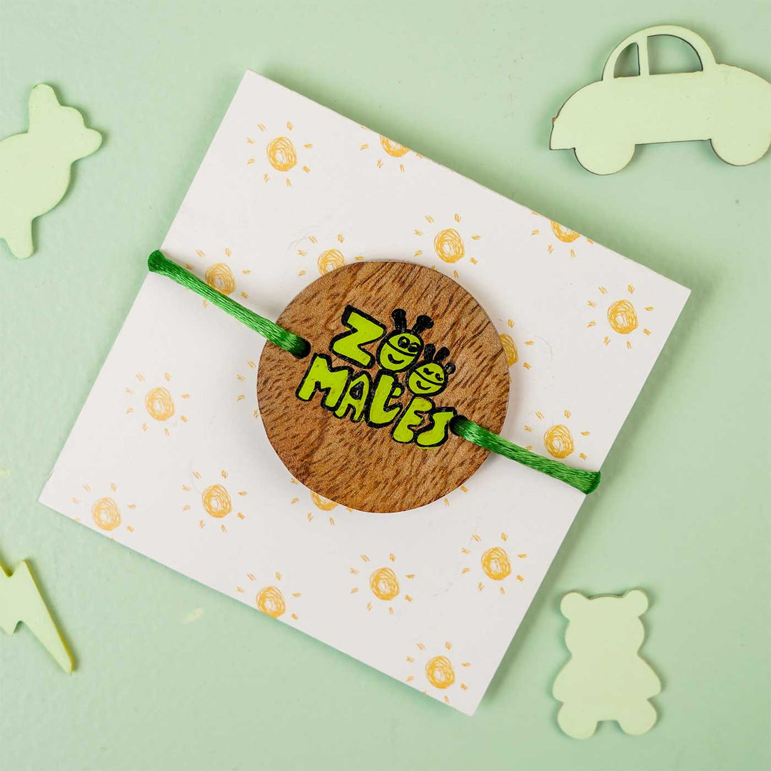 Personalized Hand Painted Zoomates Wooden Rakhi With Roli Chawal - Front View with Background Props