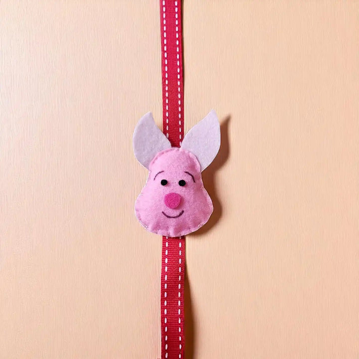 Handmade Piglet Theme Felt Kids Rakhi With Roli Chawal - Front View with Full Ribbon