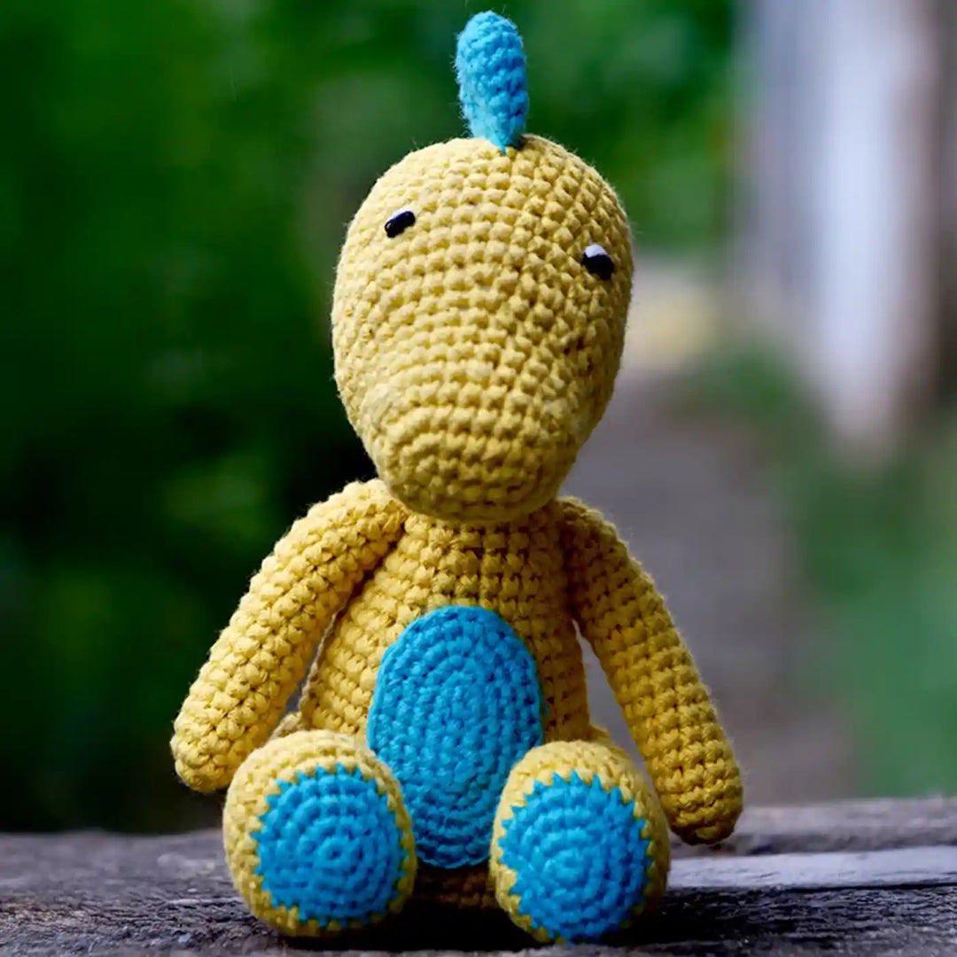 Handmade Crochet Baby Dragon Theme Kids Rakhi And Toy Combo With Roli Chawal Set Of 2 - Front View of Dinosaur Plush Sitting