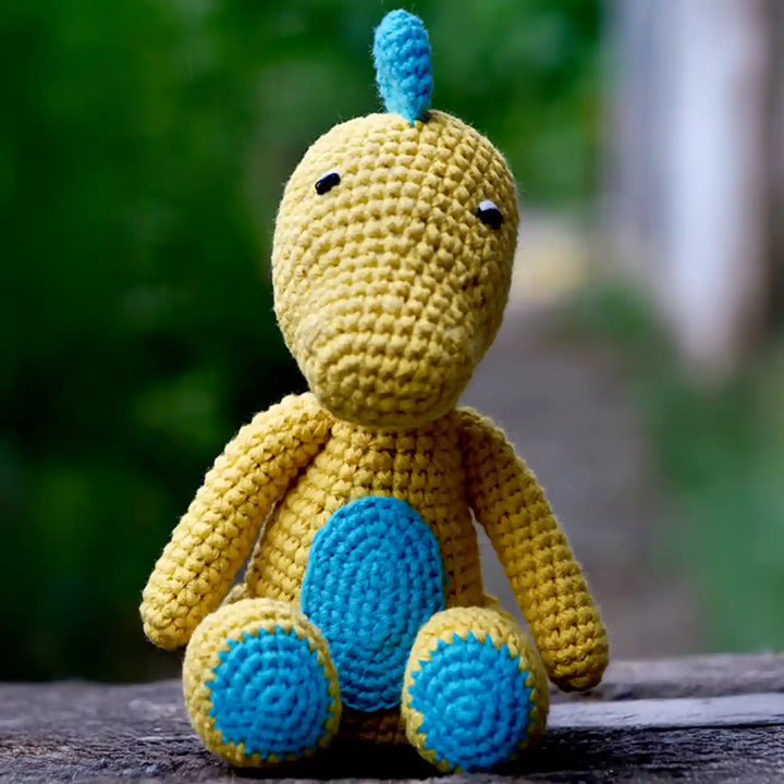 Handmade Crochet Baby Dragon Theme Kids Rakhi And Toy Combo With Roli Chawal Set Of 2 - Front View of Dinosaur Plush Sitting