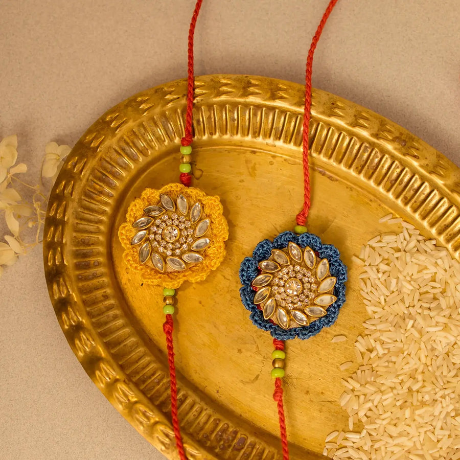 Handmade Crochet Blue And Yellow Kundan Rakhi With Roli Chawal Set Of 2 - Close-up of Two Rakhis