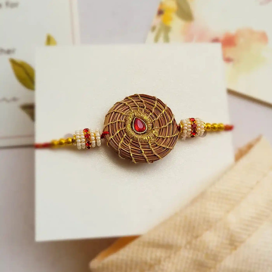 Eco Friendly Handmade Red Stone Pine Needle Rakhi With Pouch And Roli Chawal - Close-up Front View
