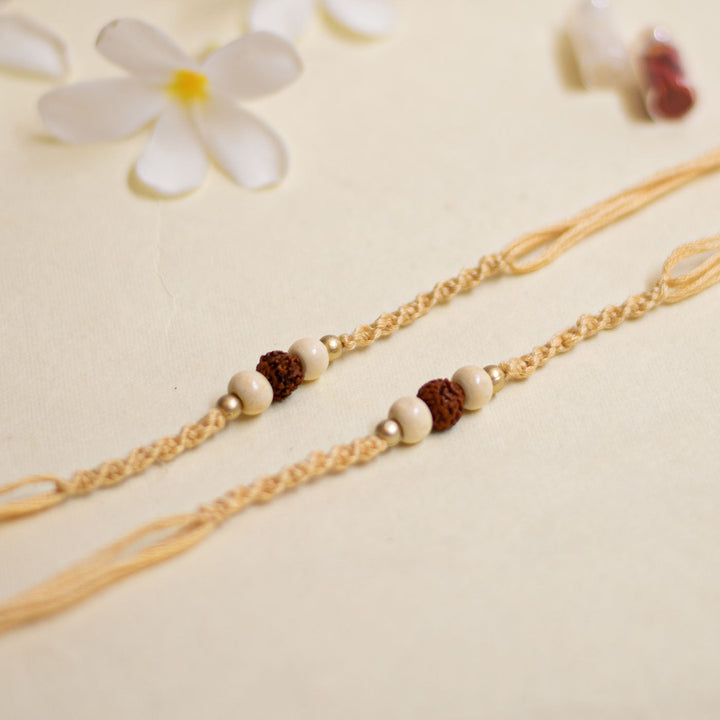 Handmade Pearl Rudraksha Rakhi With Roli Chawal - Pair of Bracelets Laid Flat
