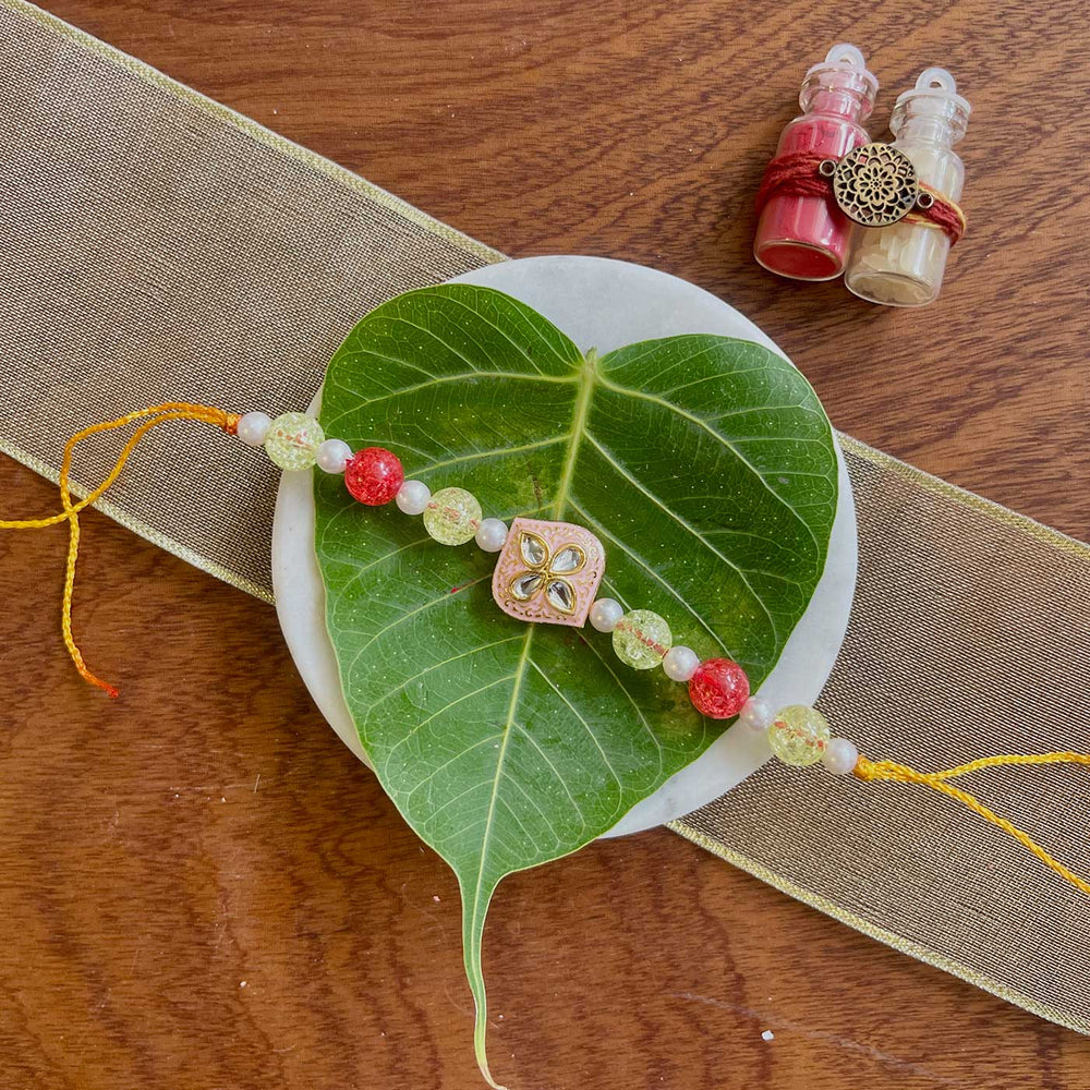Handmade Pink Flower Design Pearl And Stone Rakhi - Styled Product Display with Accessories