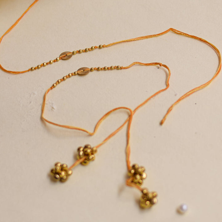 Handmade Swarn Sutra Ghungroo Bhaiya Bhabhi Rakhi With Roli Chawal - Laid Flat with Bell Clusters and Beads