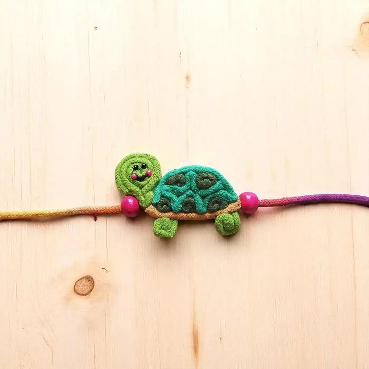 Handmade Dori Work Cute Tortoise Kids Rakhi With Roli Chawal - Close-up Front View