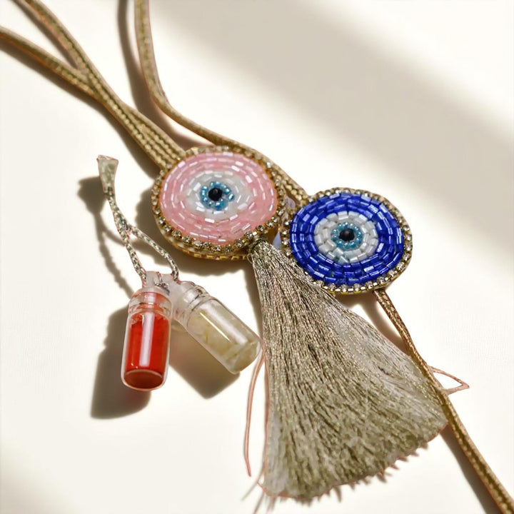 Handmade Beaded Evil Eye Bhaiya Bhabhi Rakhi With Roli Chawal Set Of 2 - Angled View with Tassel