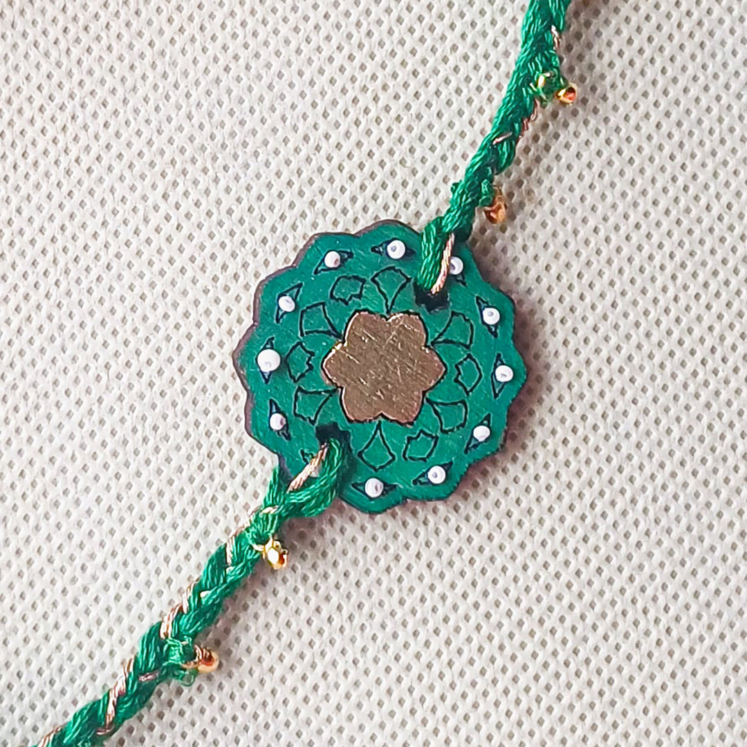 Handmade Green Ghungroo Shell And Beads Wooden Lumba Rakhi For Bhabhi With Roli Chawal - Close-up of central design