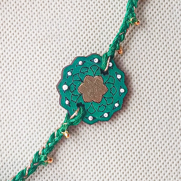 Handmade Green Ghungroo Shell And Beads Wooden Lumba Rakhi For Bhabhi With Roli Chawal - Close-up of central design