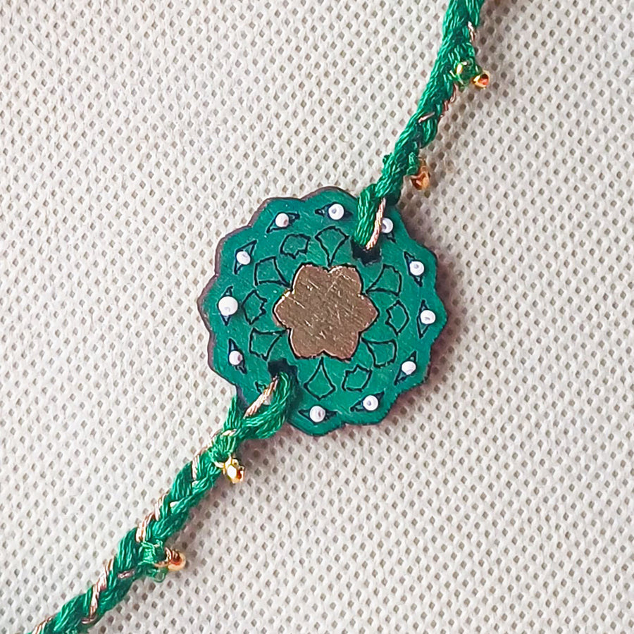 Handmade Green Ghungroo Shell And Beads Wooden Lumba Rakhi For Bhabhi With Roli Chawal - Close-up of central design