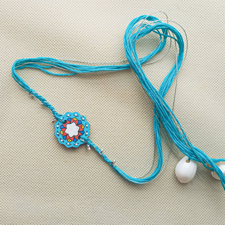 Handmade Blue Jaipuri Ghungroo Shell And Beads Wooden Lumba Rakhi For Bhabhi With Roli Chawal - Full View Laid Flat