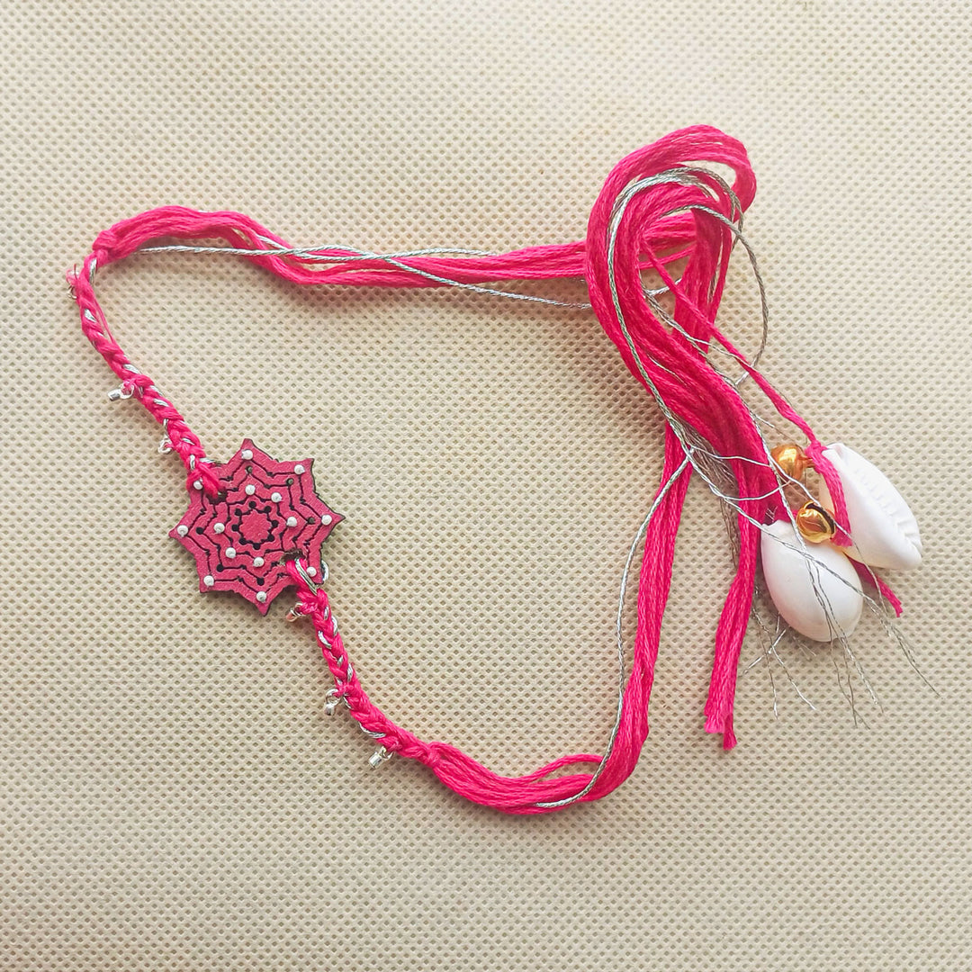Handmade Pink Star Shape Ghungroo And Beads Wooden Bhaiya Bhabhi Rakhi With Roli Chawal - Full Product Layout on Surface