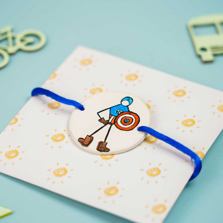 Personalized Hand Painted Captain America Clay Rakhi With Roli Chawal - Angled View on Card