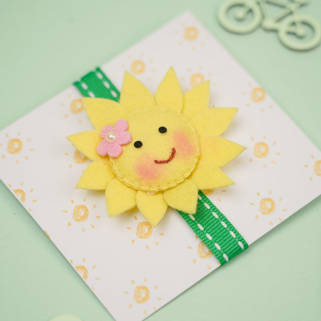 Handmade Sunflower Theme Felt Kids Rakhi With Roli Chawal - Angled View on Packaging Card