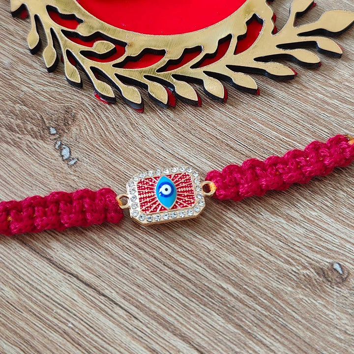 Handmade Macrame Brown Evil Eye Metal Rakhi With Roli Chawal - Close-up of central decoration