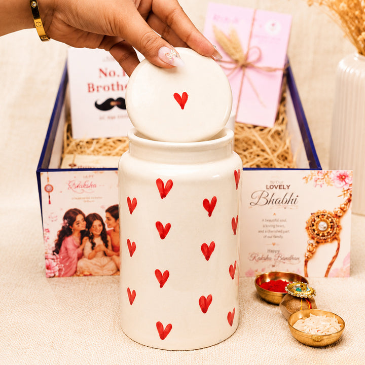 "Heartfelt Sibling Love" Jar Ceramic Rakhi Hamper With Red Sipper & Evil Eye Rakhi For Brother