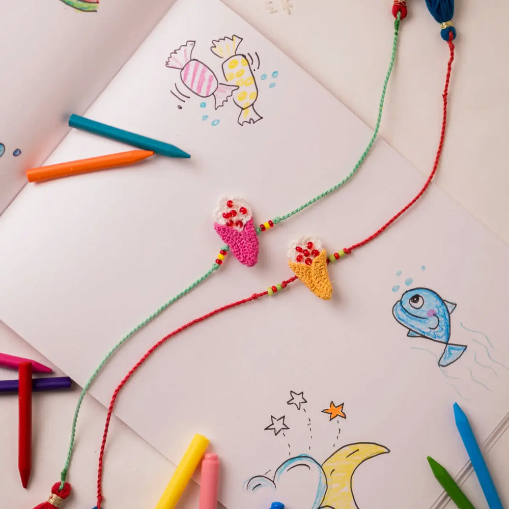 Handmade Crochet Beaded Ice Cream Theme Kids Rakhi With Roli Chawal Set Of 2 - Styled with Colored Pencils and Drawing