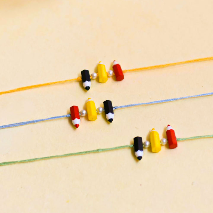 Handmade Pencil Andpearl Design Kids Rakhi With Roli Chawal - Grouped Set on Flat Surface