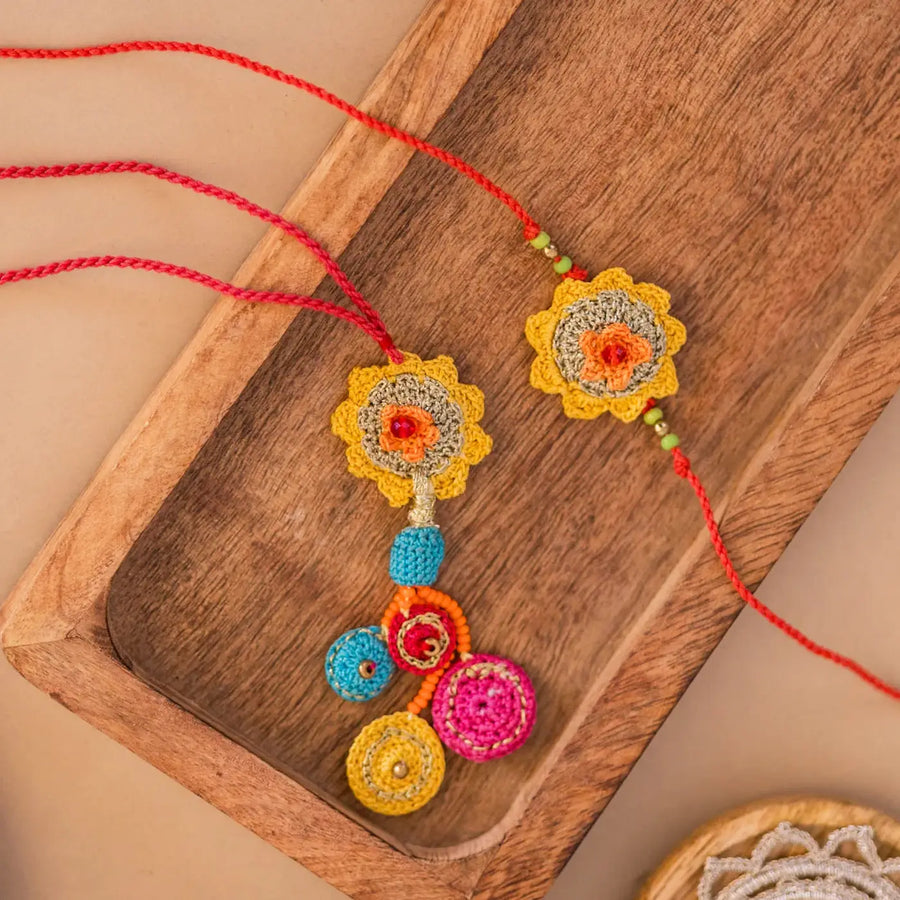 Handmade Crochet Yellow Basant Bhaiya Bhabhi Rakhi With Roli Chawal Set Of 2 - Top View on Wooden Tray
