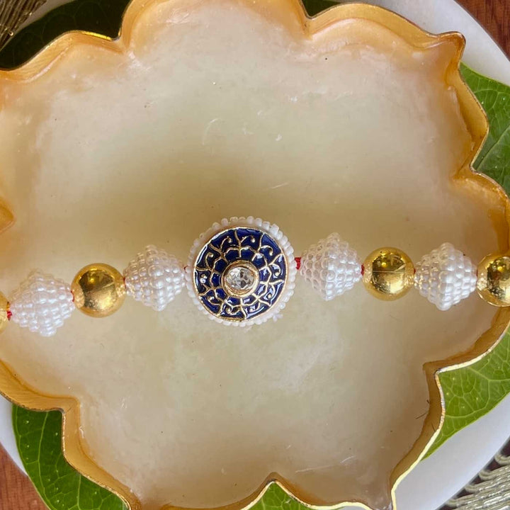 Handmade Blue And Gold Design Pearl And Stone Bhaiya Bhabhi Rakhi - Central Bead Close-up