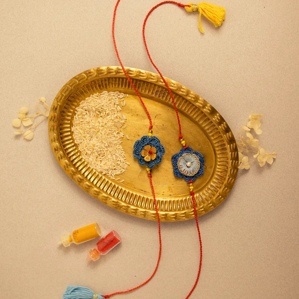 Handmade Crochet Neelam Flower Rakhi With Roli Chawal Set Of 2 - Flat lay with decorative elements