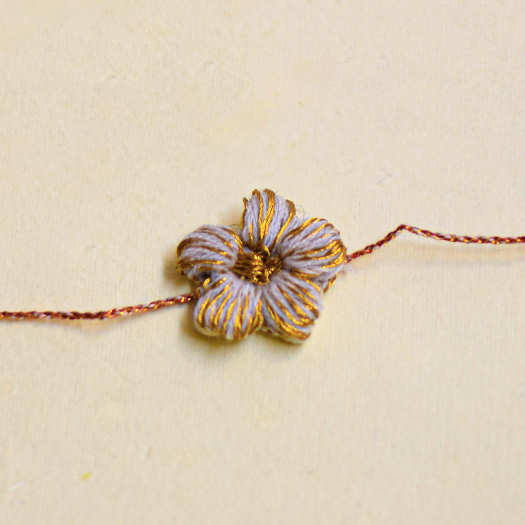 Handmade Crochet Flower And Ghungroo Design Bhaiya Bhabhi Rakhi With Roli Chawal - Single floral bracelet close-up front