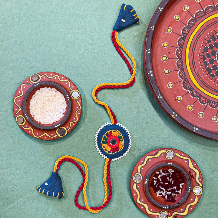 Reusable Mirror And Cotton Rope Rakhi For Brother - Product with decorative plates and powders arrangement
