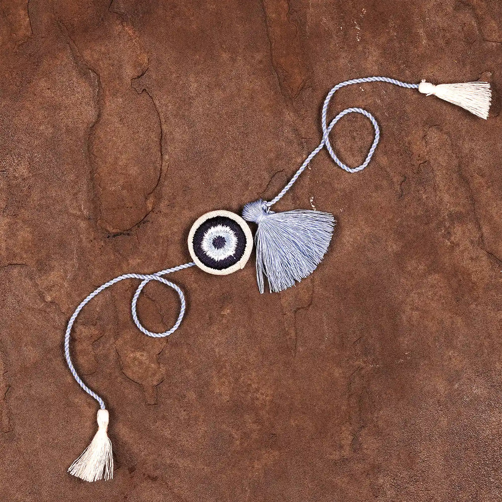 Hand Embroidered Evil Eye Rakhi With Roli Chawal - Full product layout on surface