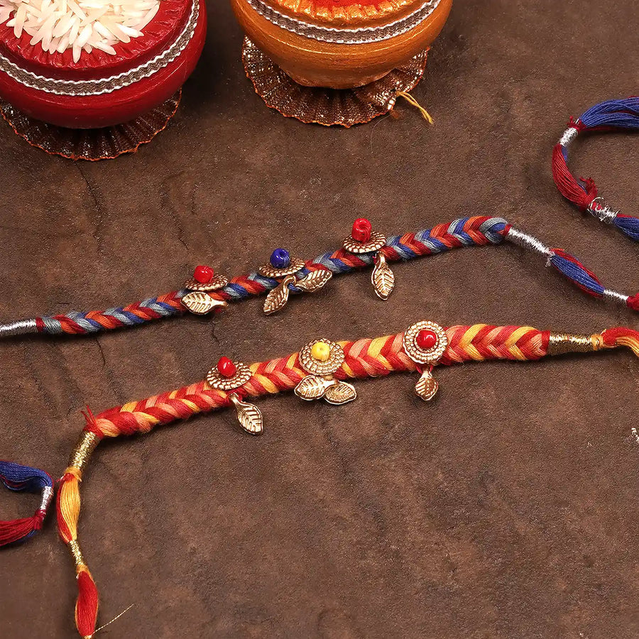 Handmade Braided Multicolour Rakhi With Roli Chawal Set Of 2 - Laid Flat with Decorative Elements
