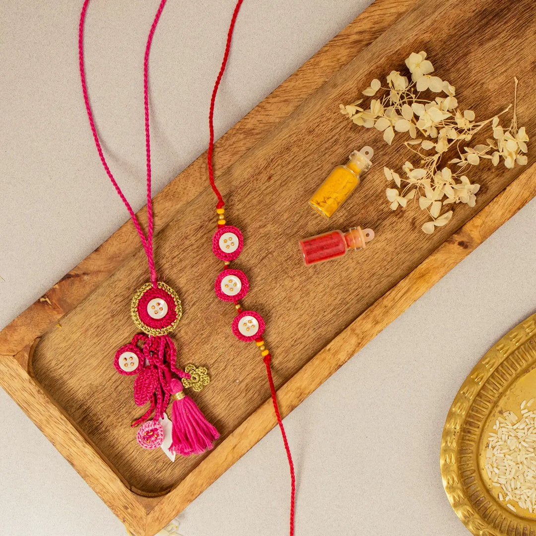 Handmade Crochet Pink Seepi Bhaiya Bhabhi Rakhi With Roli Chawal Set Of 2 - Flat Lay with Decorative Elements