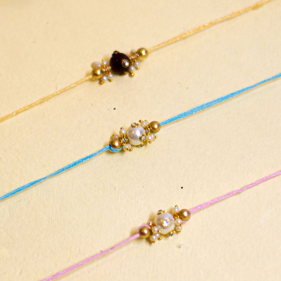 Handmade Basra Pearl Rakhi With Roli Chawal - Close-up of three bracelets