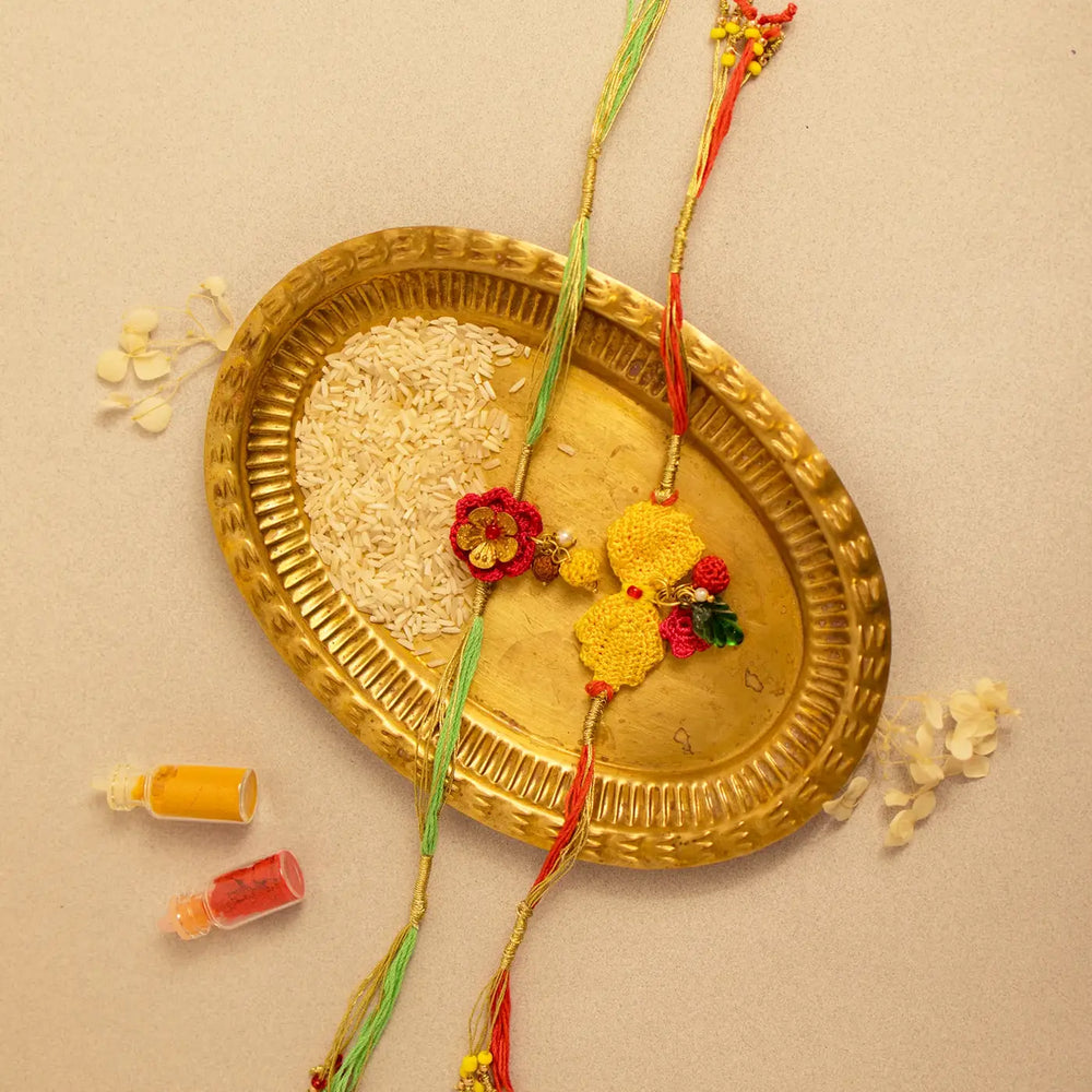 Handmade Crochet Ananya Golden Flower Rakhi With Roli Chawal Set Of 2 - Top View with Accessories
